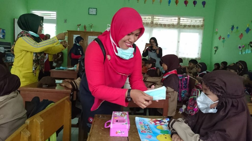 Perawat puskesmas Maninjau membagikan masker pada murid-murid