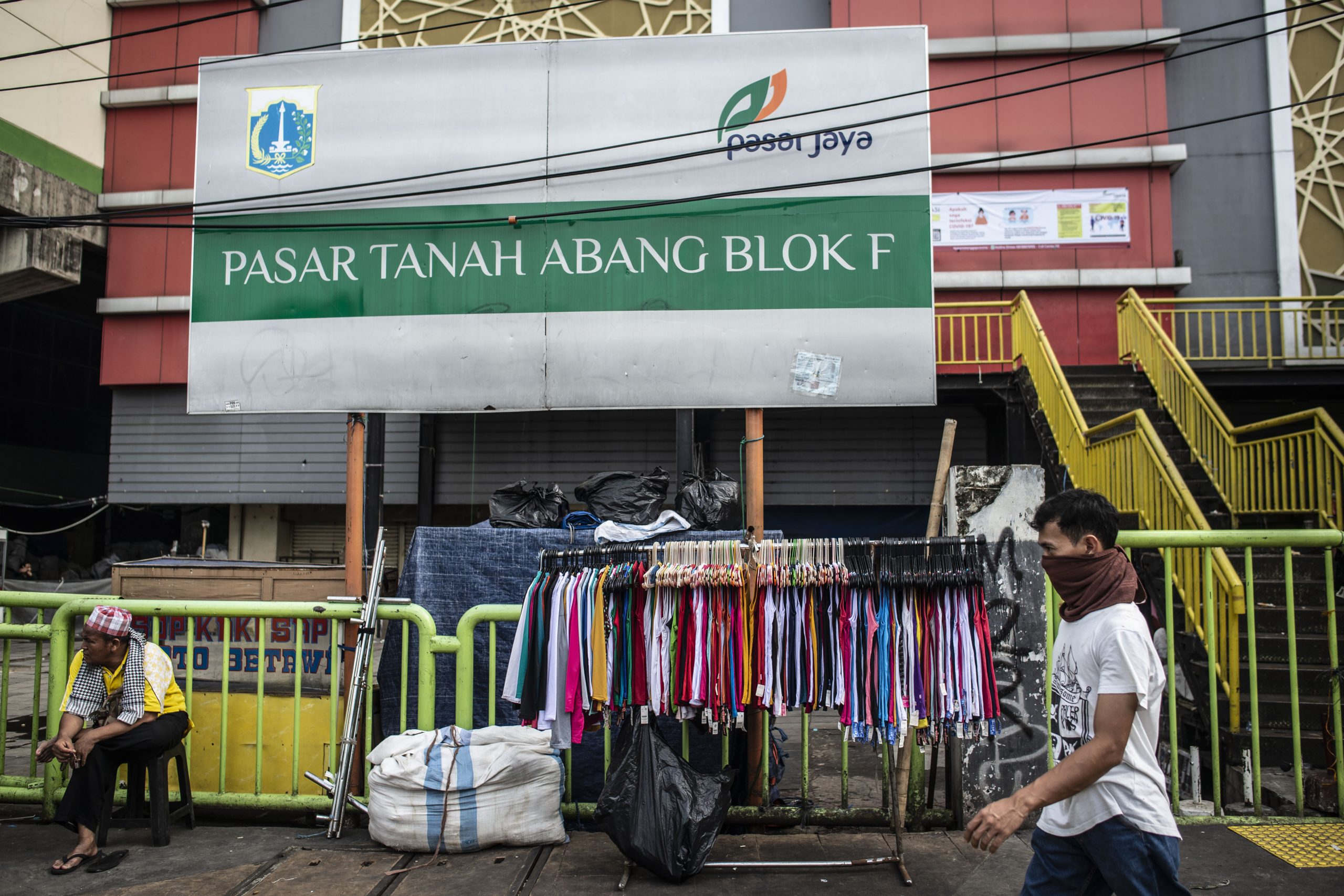 Warga beraktivitas di depan Pasar Tanah Abang Blok F yang tutup di Jakarta, Jumat (27/3/2020). Dalam rangka pencegahan dan menekan angka penularan virus Corona (COVID-19), Perumda Pasar Jaya menutup sementara Pasar Tanah Abang Blok A, B dan F mulai 27 Maret hingga 5 April 2020. ANTARA FOTO/Aprillio Akbar