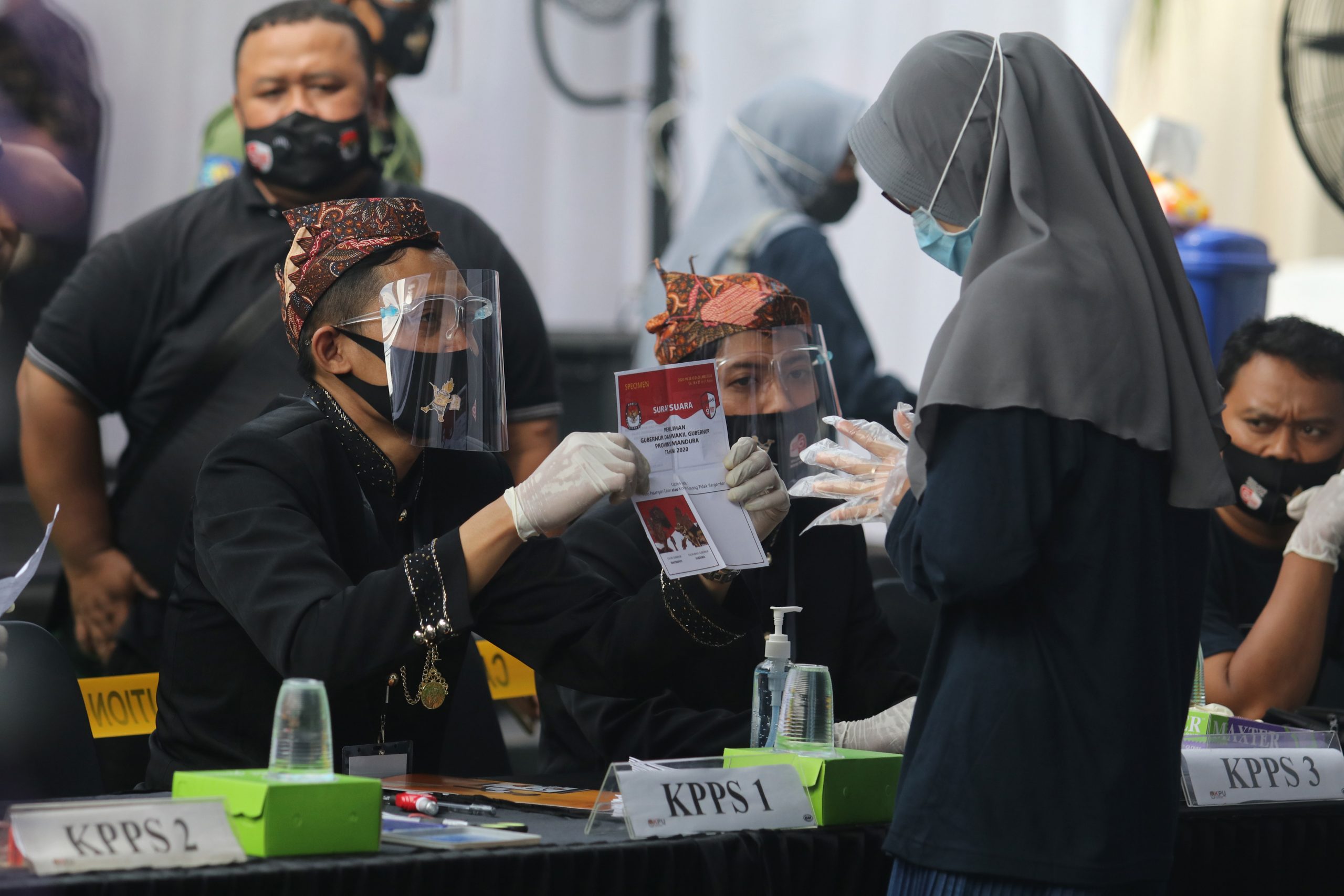 Petugas menggunakan masker, pelindung wajah, dan kaos tangan memberikan surat suara kepada calon pemilih saat simulasi nasional pemungutan suara Pilkada serentak di Kediri, Jawa Timur, Sabtu (31/10/2020). Simulasi nasional yang dihadiri ketua KPU Arief Budiman dan perwakilan KPU tingkat kota/kabupaten wilayah Indonesia timur tersebut sebagai upaya kesiapan KPU menyelenggarakan Pilkada serentak dengan menerapkan protokol kesehatan guna menanggulangi penyebaran COVID-19. ANTARA FOTO/Prasetia Fauzani/hp.