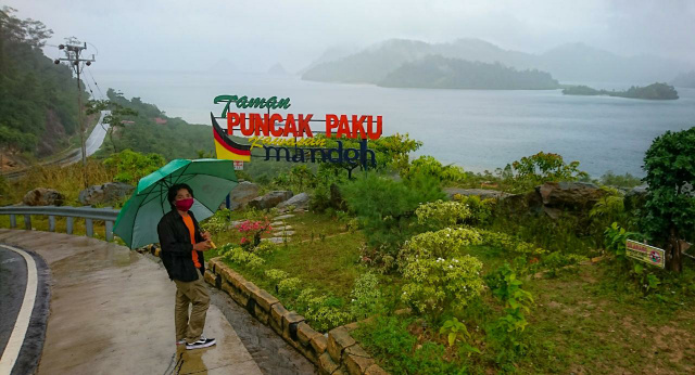 Seorang pengunjung berfoto dengan latar Taman Puncak Paku Mandeh di objek wisata Mandeh, Pesisir Selatan, belum lama ini. Kabarnya nama puncak itu akan diganti dengan nama orang nomor satu di Indonesia, yakni Puncak Jokowi (foto: givo)