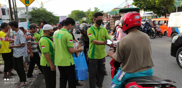Sekretaris LDII Kota Padang HM Abdillah memberikan takjil kepada pengendara yang melintas di kawasan Ulak Karang pada Rabu (5/5)