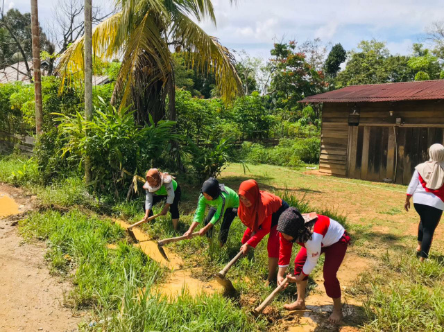Anggota DPRD Dharmasraya Sasmi Erli, S.Pd, M.PD.I, bersam kaum ibu lainnya bersitungkin menggali bandar, agar air mengenangi jalan dapat teraliri hingga sungai pembuangan.