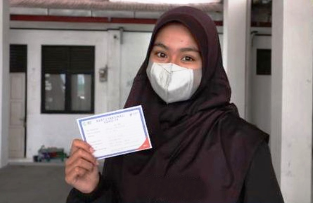 Nayla memperlihatkan kartu vaksinasi usai mendapat vaksin Covid-19.