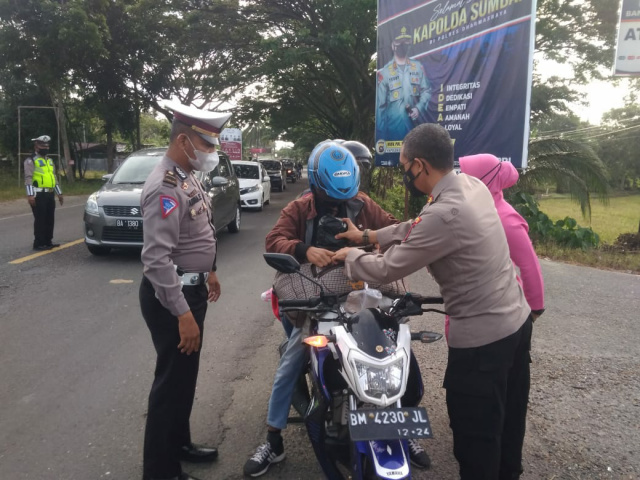 Kapolres Dharmasraya AKBP Anggun Cahyono., S I.K., M.T, bagikan nasi bungkus dan sarapan pagi kepada pengendara melintas saat digelarnya Jumat barokah