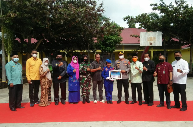 Kombes Pol Nina Febri Linda, S. H., M. M, Kabid Kum Polda Sumbar, bersama Kapolres Dharmasraya AKBP Nurhadiansyah, serahkan piagam kepada Polisi Cilik Polres Dharmasraya, dalam rangka Sumdarsin anak usia 6-11 tahun dalam rangka kegiatan pelaksanaan vaksinasi di SDN Rujukan Nomor: 20 Sitiung.