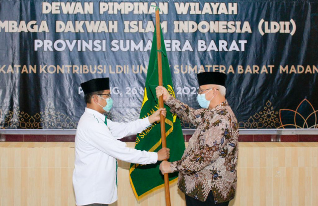Ketua Umum DPP LDII KH Chriswanto Santoso (kanan) memberikan pataka kepada Penjabat Ketua DPW LDII Sumbar Afrizal Yaman dalam Rapat Pimpinan Wilayah (Rapimwil) LDII Sumbar pada Sabtu (26/3).