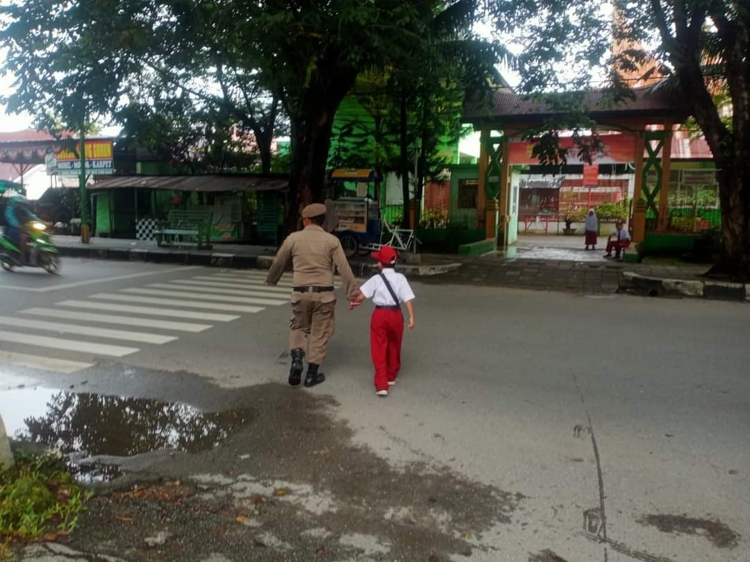 Petugas Satpol PP Padang bantu siswa SD menyeberang jalan