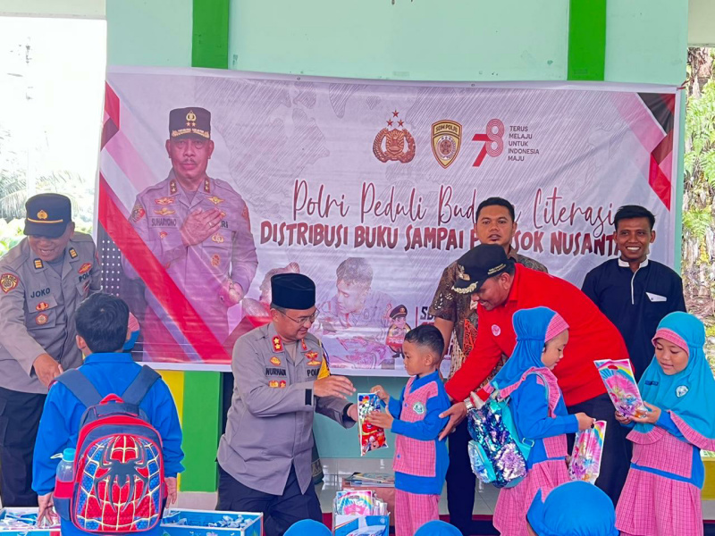 kapolres Dharmasraya AKBP Nurhadiansyah, S. I. K.  Saat membagikan buku baca kepada anak-anak PAUD.